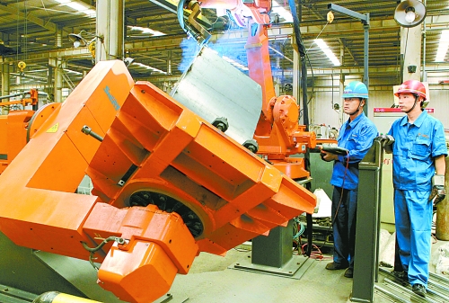 圖為龍工集團中原公司的職工正在操作機器人焊接裝載機。