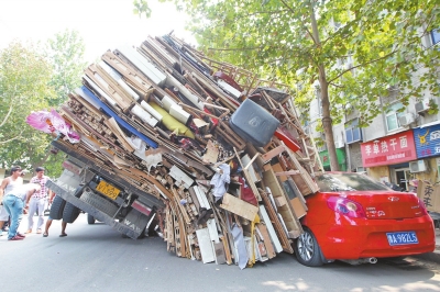 紅色小轎車被砸，卡在路邊動彈不得。