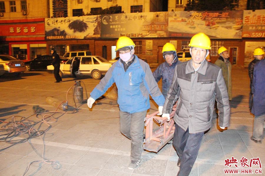 23點(diǎn)56分，第一塊兒廣告牌已經(jīng)分割完畢，地面上的20多名工人將拆除下來(lái)的鋼件撞車(chē)運(yùn)走。