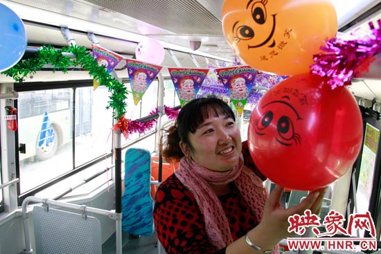 鄭州快速公交B3區(qū)間線車長(zhǎng)李鵬云在車廂里懸掛氣球，布置圣誕車廂，營(yíng)造歡樂圣誕氛圍