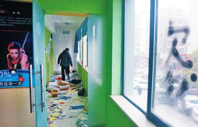 　健身會所地上一片狼藉，玻璃上噴著黑色“欠錢”二字。