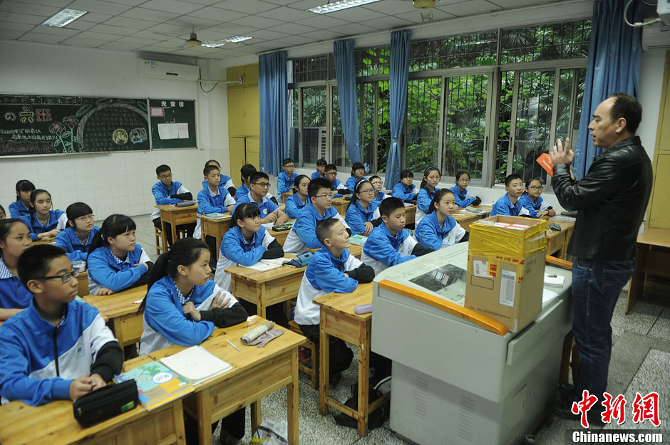 圖為老師正在向同學(xué)們講解用非智能手機(jī)對(duì)他們的好處。