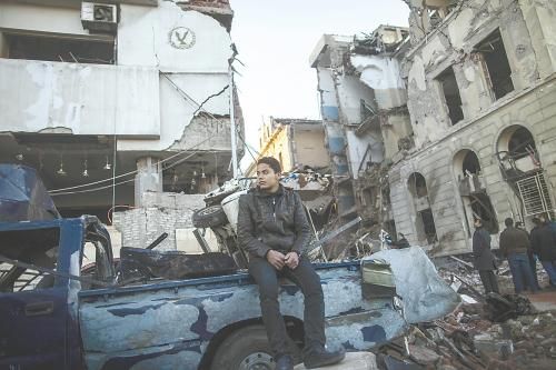 埃及曼蘇拉市警察局24日遭汽車(chē)炸彈襲擊，被疑是穆兄會(huì)的報(bào)復(fù)。圖為一名男子在被炸毀的警察局前。