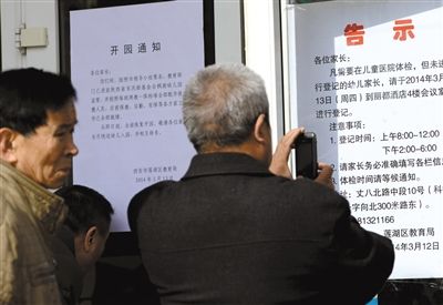 昨日，家長(zhǎng)在西安市楓韻幼兒園查看有關(guān)兒童體檢的告示。