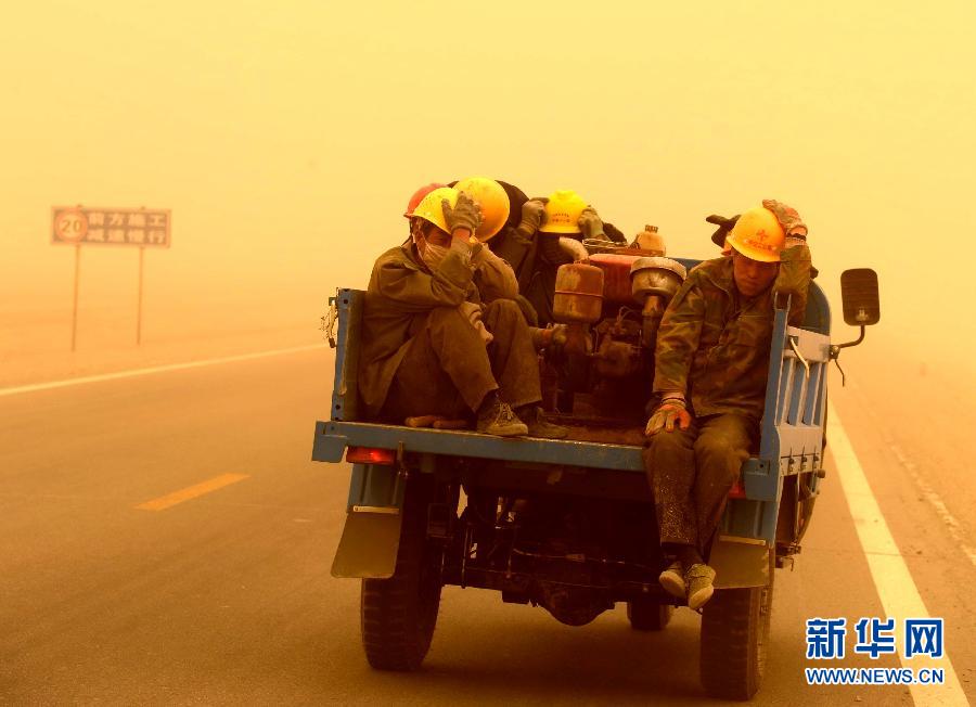 4月23日，一輛拉載公路施工人員的三輪車在沙塵暴中行駛在酒泉市瓜州縣城郊的公路上。