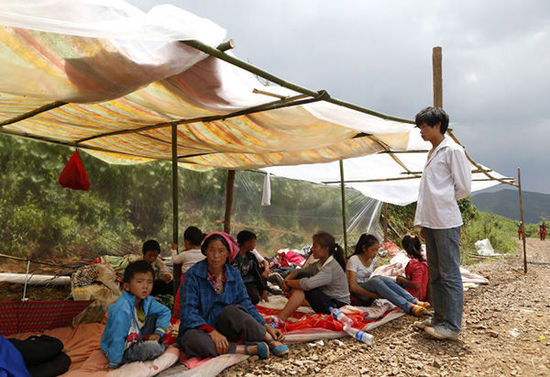 暴雨馬上來臨，村民們在簡易帳篷下躲雨。澎湃新聞 程藝輝 圖