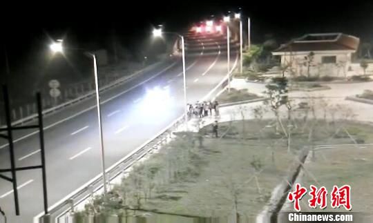 看到車輛經(jīng)過，孩子們便急忙跑到一旁的花圃上?！【焦﹫D　攝