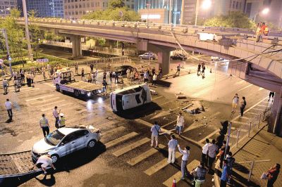 路虎沖下國(guó)貿(mào)橋砸中一輛起亞轎車(chē)，橋上厚達(dá)幾十厘米的水泥護(hù)欄被撞斷，碎石四處散落，數(shù)十群眾在現(xiàn)場(chǎng)圍觀。