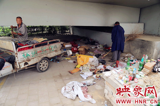 負責(zé)高架橋下綠化的人員在清理流浪漢留下的垃圾和雜物。