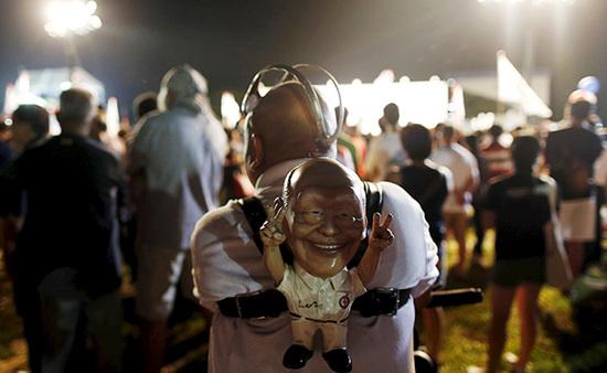 9月4日，新加坡，執(zhí)政黨的一場(chǎng)集會(huì)上，一名支持者背著一個(gè)李光耀的人偶。