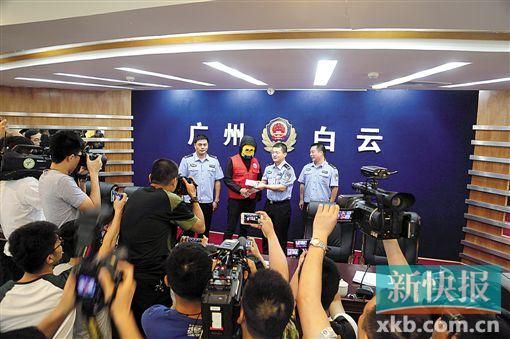 因舉報涉毒案件線索而獲獎的“快遞小哥”戴著面具領(lǐng)取獎金。