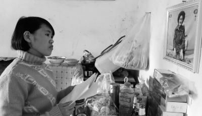 錢仁鳳站在母親遺像前。未能見母親最后一面是她的一大遺憾。