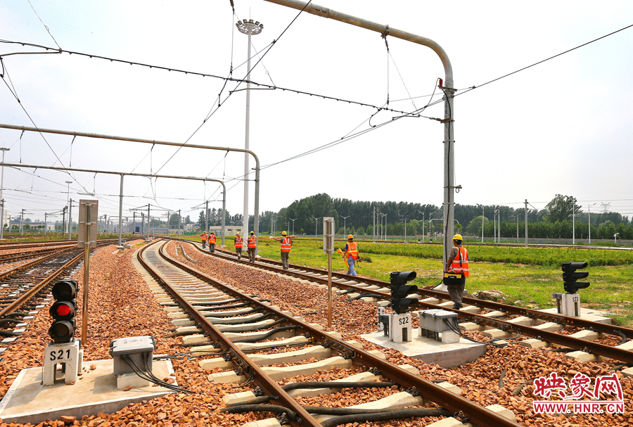 在太陽(yáng)的直射下，檢修工人扛著沉重的設(shè)備向施工地點(diǎn)出發(fā)