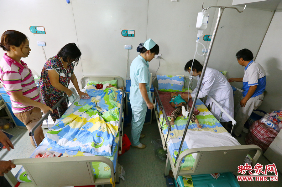 手術(shù)前，畫面右側(cè)的大龍正在接受醫(yī)生的檢查，左側(cè)的小龍還在熟睡。