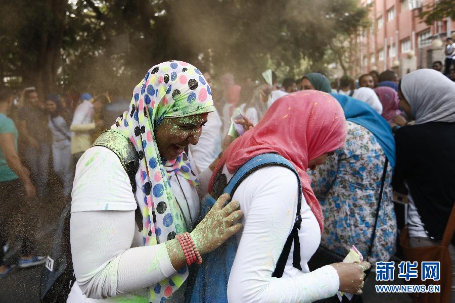 10月16日，在埃及首都開羅，兩名女青年在“彩色跑”活動中躲避人們拋撒的彩色粉末。