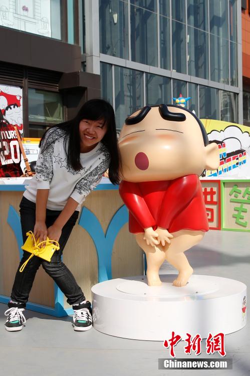 4月22日，游客與蠟筆小新合影?！跋灩P小新25周年紀(jì)念特展”日前在北京開展，吸引了不少市民游客。