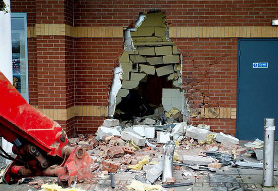 劫匪利用挖掘機(jī)的機(jī)械臂移走ATM機(jī)，留下滿地狼藉