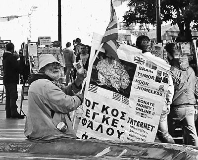 自債務危機爆發(fā)以來，希臘承諾實施以減薪、增稅、裁員和私有化為主要內容的緊縮和改革政策。一系列的緊縮措施使民眾生活受到嚴重影響，約1/4的家庭陷入貧困。圖為今年1月希臘大選期間，在雅典市中心國會大廈前廣場乞討的老人。