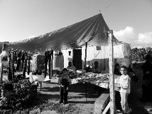 黎巴嫩一敘利亞難民營(yíng)，難民支起攤鋪賣衣服掙錢。