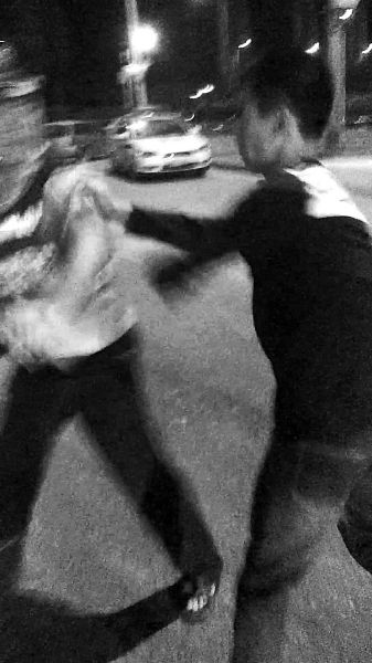 一名男子扯著民警的反光背心一路追打。