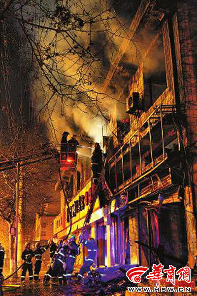 昨日22時10分，西安市豐慶路南小巷南口，消防官兵架梯子登上二樓施救 本組圖片由本報記者 閆文青 攝