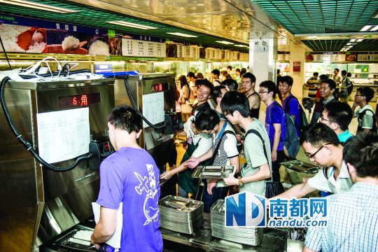 昨日，華南理工大學(xué)一食堂內(nèi)，學(xué)生們正在使用新安裝的自動打飯機打飯。中新社發(fā)