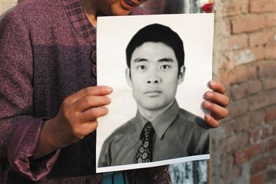 5月19日，朝陽北路，母親捧著張東文的遺像。新京報(bào)記者 侯少卿 攝