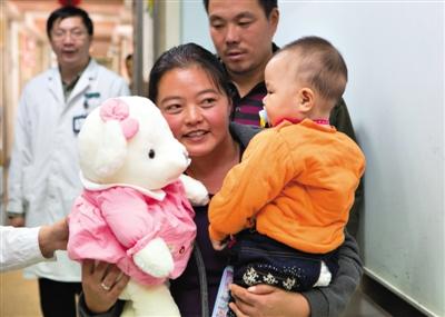 昨日上午，被扎針女嬰的母親抱著孩子和醫(yī)護(hù)人員送的玩偶準(zhǔn)備出院，院方稱孩子術(shù)后恢復(fù)良好。記者 高瑋 攝