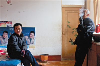 父親抽煙，兒子不語。逃跑的越南新娘，給袁迎賓父子帶來的是失落。新京報(bào)記者 周崗峰 攝