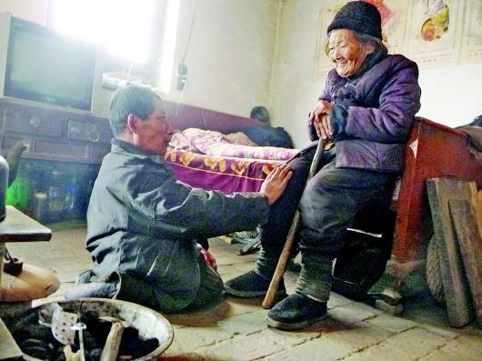 52歲的劉蘭山每天靠爬行照顧90歲的老母親。孫國(guó)祥 攝