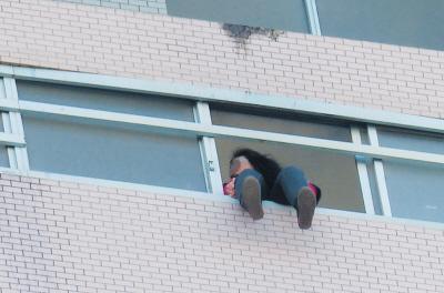 28樓的窗臺(tái)上坐著一名女子，其兩條腿耷拉在室外，不停地?cái)[動(dòng)。