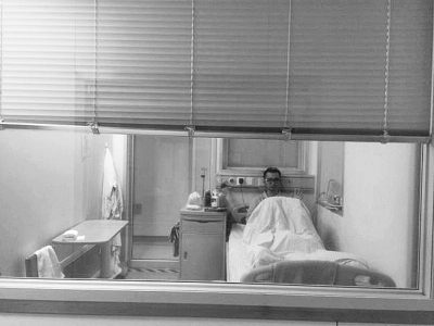 楊杰在醫(yī)院隔離病房中，沖記者揮了揮手。