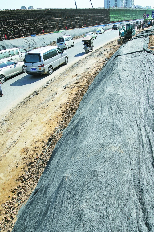 豐樂路與北三環(huán)交叉口，修路的土被歸置得整整齊齊，并用黑網(wǎng)覆蓋，既保暢通又避免了揚(yáng)塵。