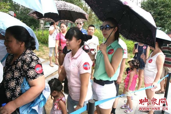 佩戴信息廣播臂貼的聽(tīng)眾們?cè)谂抨?duì)等候坐帆船。