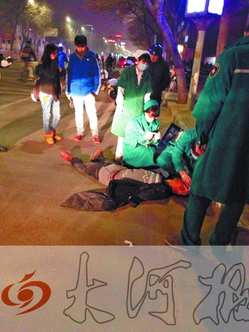 醉漢躺在地上，醫(yī)護(hù)人員對(duì)其進(jìn)行檢查。